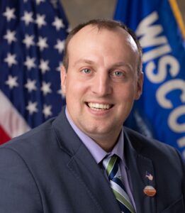 A Smiling Man Headshot in a Black SUit